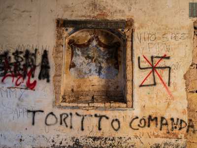 Tra gli antichi simboli si distingue solo una corona regale da cui cadono due tendaggi rossi, il tutto dominato da un decoro vegetale a otto petali sull�arcata